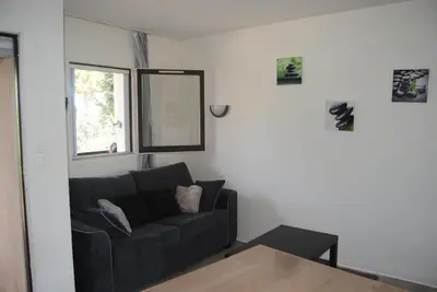 a living room with a black couch and a window at Les Palmiers à 700m de la mer in Nice