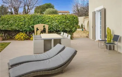 a patio with chairs and a table and a fence at Awesome Home In La Gaude With Kitchen in La Gaude