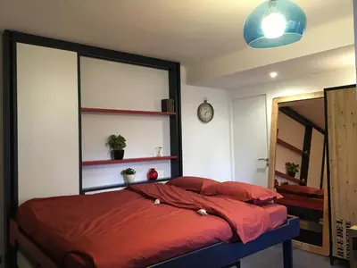 a bedroom with a bed with red sheets and a mirror at Studio 33 in Nice
