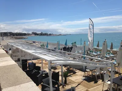 a group of chairs and umbrellas on a beach at Le Cros de Cagnes in Cagnes-sur-Mer