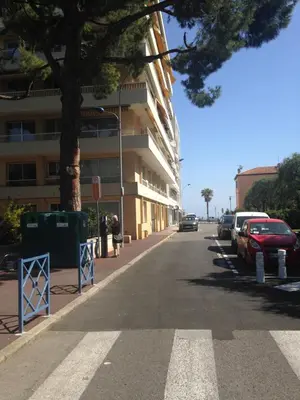 a street with cars parked on the side of a building at Le Cros de Cagnes in Cagnes-sur-Mer
