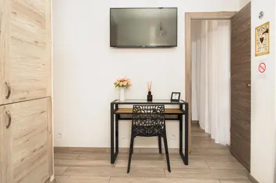 a dining room table with a chair and a television on the wall at Nice Centre Flat - Modern, Quiet and Brand New in Nice