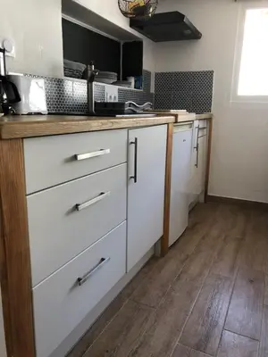 a kitchen with white cabinets and a wooden floor at F2 Centre - Gare in Nice