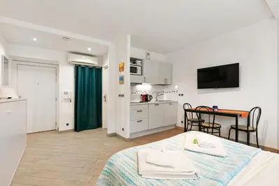 a room with a bed and a kitchen with a table at Les Oranges Five Stars HolidayHouse in Nice