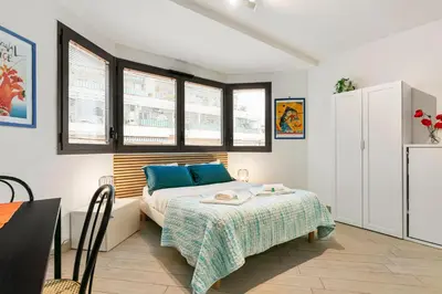 a bedroom with a bed with blue pillows and windows at Les Oranges Five Stars HolidayHouse in Nice