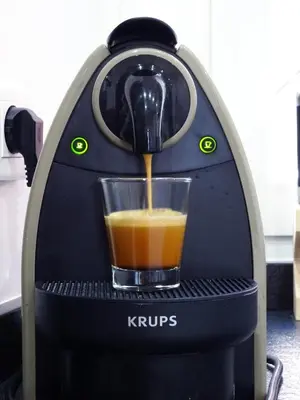 an orange juice is being poured into a coffee maker at 
