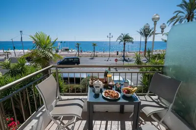 a table with food on a balcony with a view of the beach at 