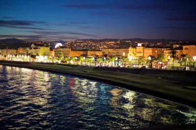 a city at night with a body of water at 