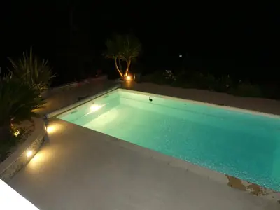 a swimming pool at night with lights on it at Mikado in La Gaude