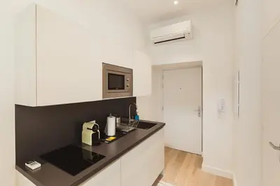 a kitchen with white cabinets and a black counter top at Residence Tonduti in Nice