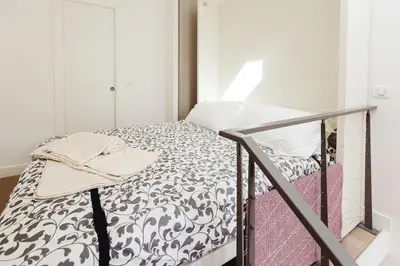 a bed with a black and white comforter in a room at Residence Tonduti in Nice