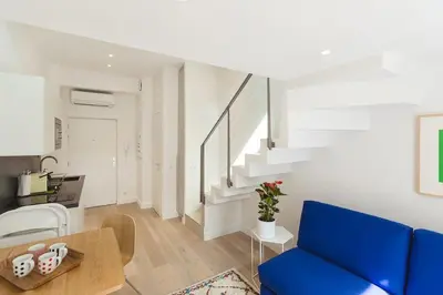 a living room with a blue couch and stairs at Residence Tonduti in Nice