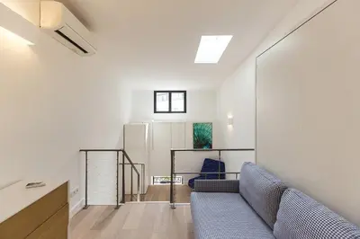 a living room with a blue couch and a window at Residence Tonduti in Nice