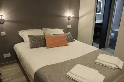 a bedroom with a large bed with pillows and a mirror at Appartement 3 pièces Nice Promenade des anglais dernier étage vue mer solarium in Nice
