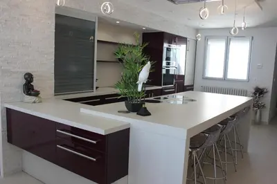 a kitchen with a large island with a white counter top at Appartement 3 pièces Nice Promenade des anglais dernier étage vue mer solarium in Nice