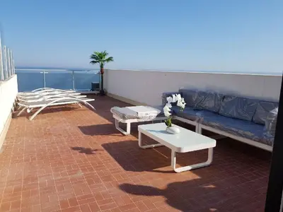 a living room with a couch and a table at Appartement 3 pièces Nice Promenade des anglais dernier étage vue mer solarium in Nice