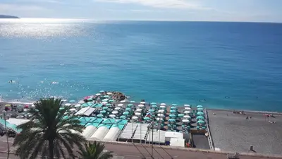 an aerial view of a beach with umbrellas and the ocean at Appartement 3 pièces Nice Promenade des anglais dernier étage vue mer solarium in Nice