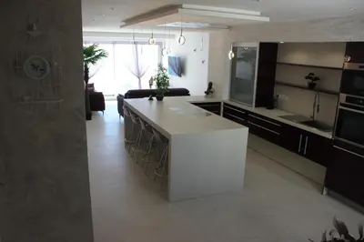 a kitchen with a white island in a room at Appartement 3 pièces Nice Promenade des anglais dernier étage vue mer solarium in Nice