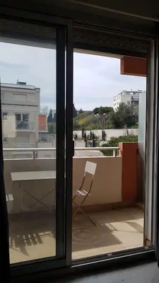 a glass window with a chair on a balcony at Nissa La Bella in Nice