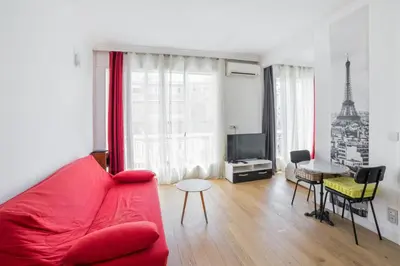 a living room with a red couch and a table at Studio Guiglia - Welkeys in Nice