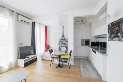 a kitchen with a table and chairs in a room at Studio Guiglia - Welkeys in Nice