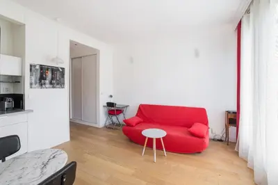 a living room with a red couch and a table at Studio Guiglia - Welkeys in Nice