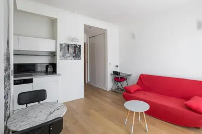 a living room with a red couch and a table at Studio Guiglia - Welkeys in Nice