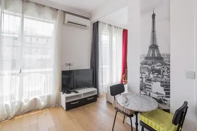 a living room with a table and a television and a tower at Studio Guiglia - Welkeys in Nice