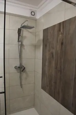a bathroom with a shower with a wooden wall at Stylish 2 Room Flat 60 meters to the beach in Nice
