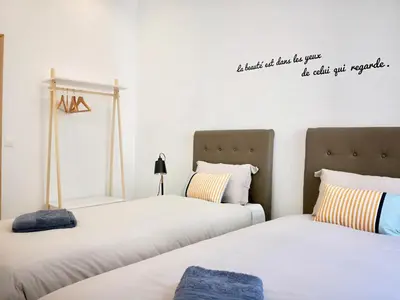a bedroom with two beds with a quote on the wall at Appartement Urban 3 in Nice