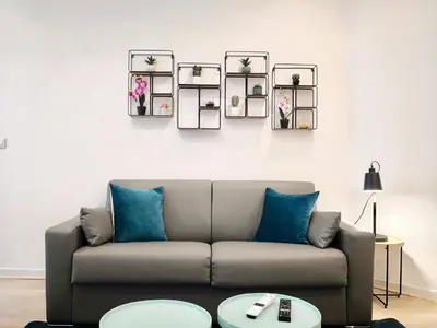 a living room with a couch and three mirrors at Appartement Urban 3 in Nice