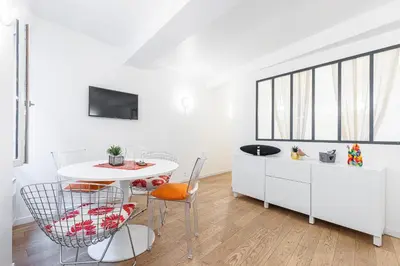 a white dining room with a table and chairs at Quiet and cosy 1bdr in Vieux Nice! in Nice