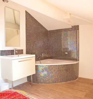 a bathroom with a tub and a sink and a mirror at La Garibaldi in Nice