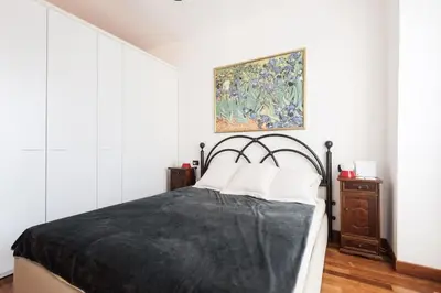 a bedroom with a bed and a painting on the wall at Irene Apartment in Nice