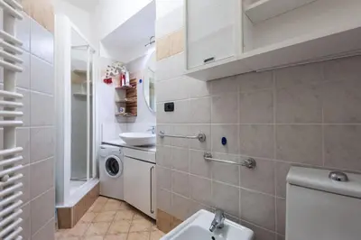 a bathroom with a sink and a washing machine at Irene Apartment in Nice