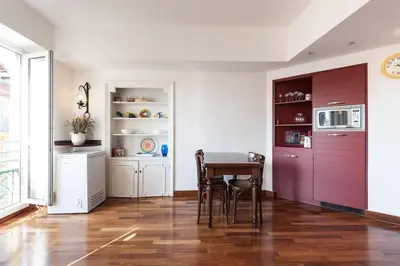 a dining room with a table and a kitchen at Irene Apartment in Nice