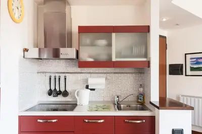 a kitchen with red cabinets and a sink at Irene Apartment in Nice