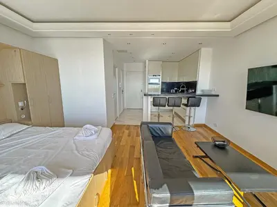 a room with a bed and a table in it at CARIATIDES STUDIO - PROMENADE HOLIDAY in Nice