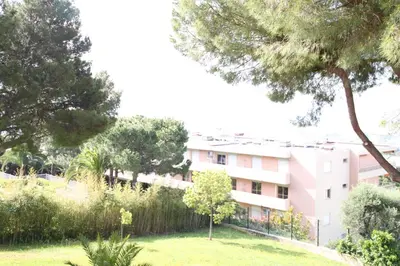 a view of a building with trees and a yard at Oasis Méditerranéen Piscine & Parking Calme absolu in Nice