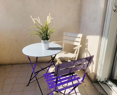 a table and chairs on a balcony with a potted plant at Le Californie Côte d'azur plage les pieds dans L'eau in Nice