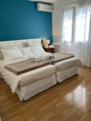 a large bed in a bedroom with a blue wall at Villa Antoline in Cagnes-sur-Mer
