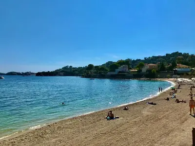a group of people on a beach near the water at Les Jasmins in Beaulieu-sur-Mer
