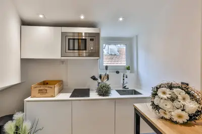 a kitchen with white cabinets and a microwave at MY CASA - LA CIVETTE - Place Garibaldi in Nice