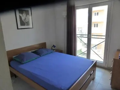 a bedroom with a blue bed and a large window at Palais des Domes Gloria in Nice