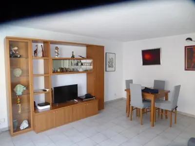 a living room with a dining table and a television at Palais des Domes Gloria in Nice