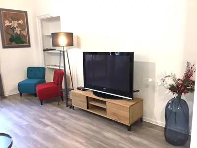 a living room with a flat screen tv and a chair at Port de Nice in Nice