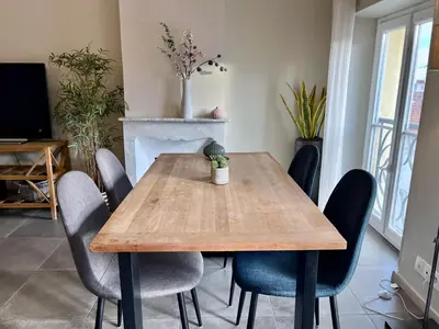 a dining room with a wooden table and chairs at Promenade sur les toits in Nice
