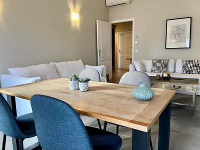 a living room with a wooden table and chairs at Promenade sur les toits in Nice