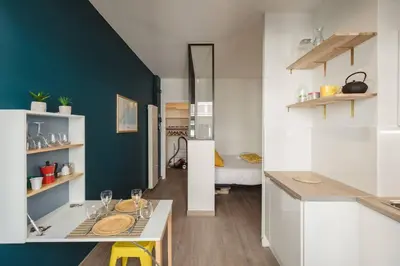 a kitchen with white cabinets and a blue wall at Nicelidays - Le Berlioz - city central - 7min from beaches in Nice