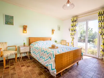a bedroom with a bed and a chair and a window at Holiday Home La Mesnière by Interhome in Gattières